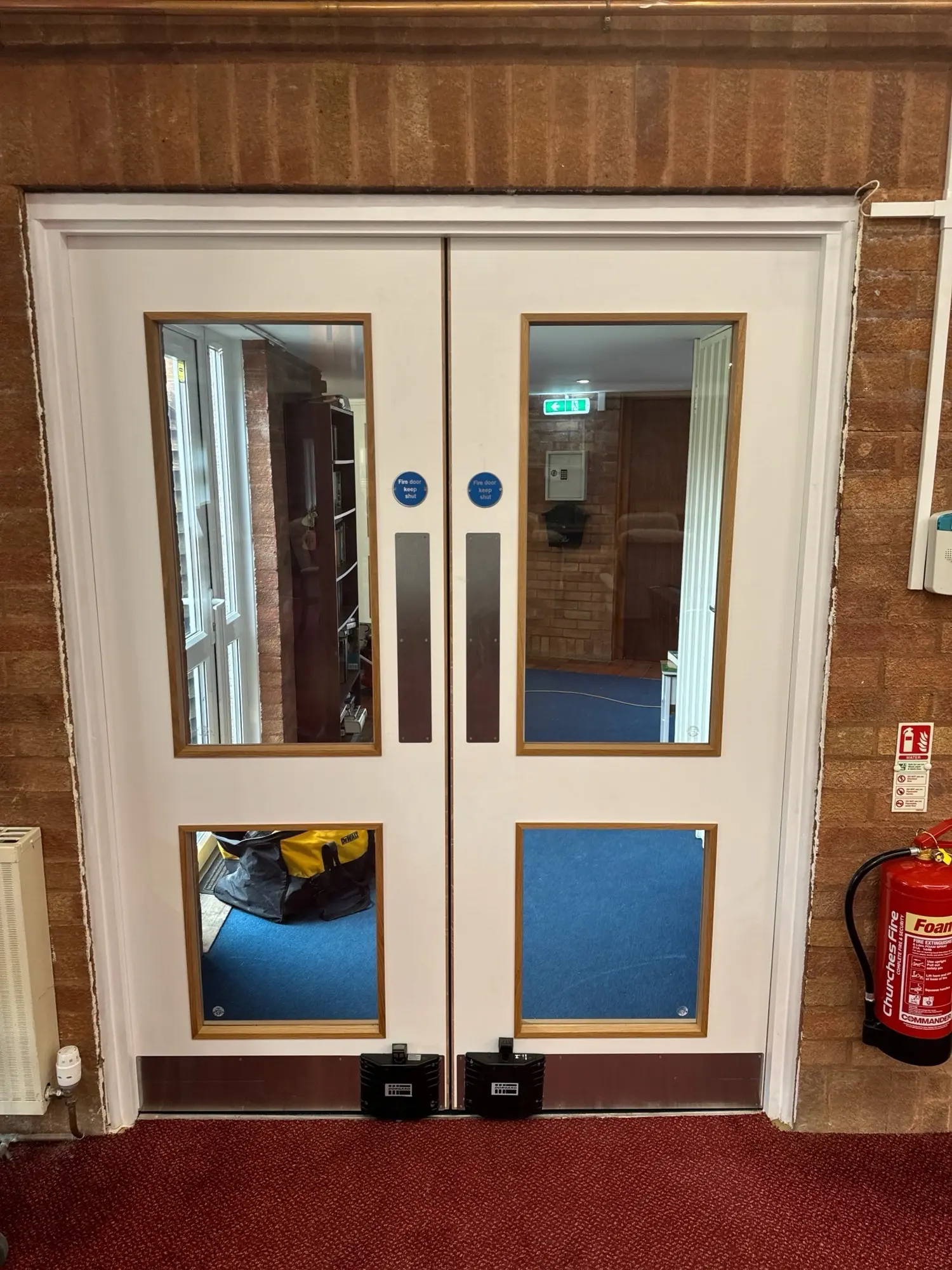 White glazed double doors installed in an occupied communal building