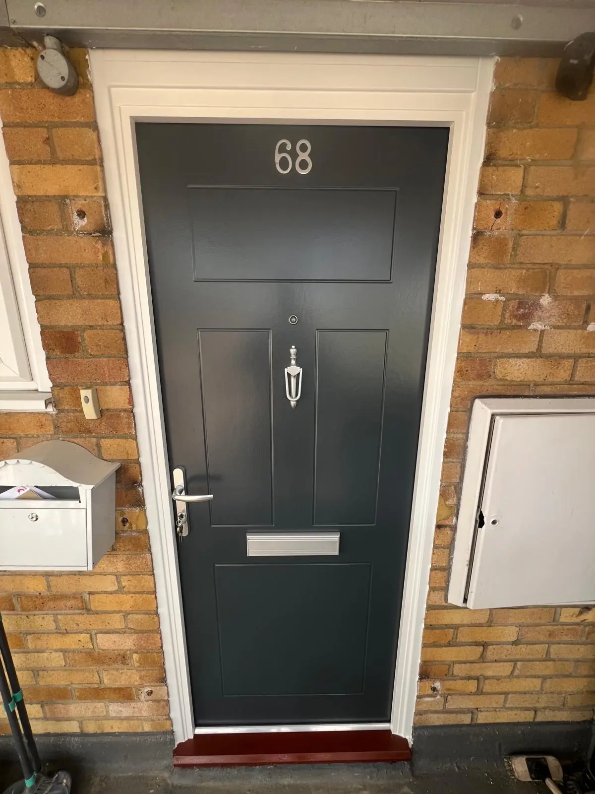 Dark panelled timber residential entrance door in a white frame