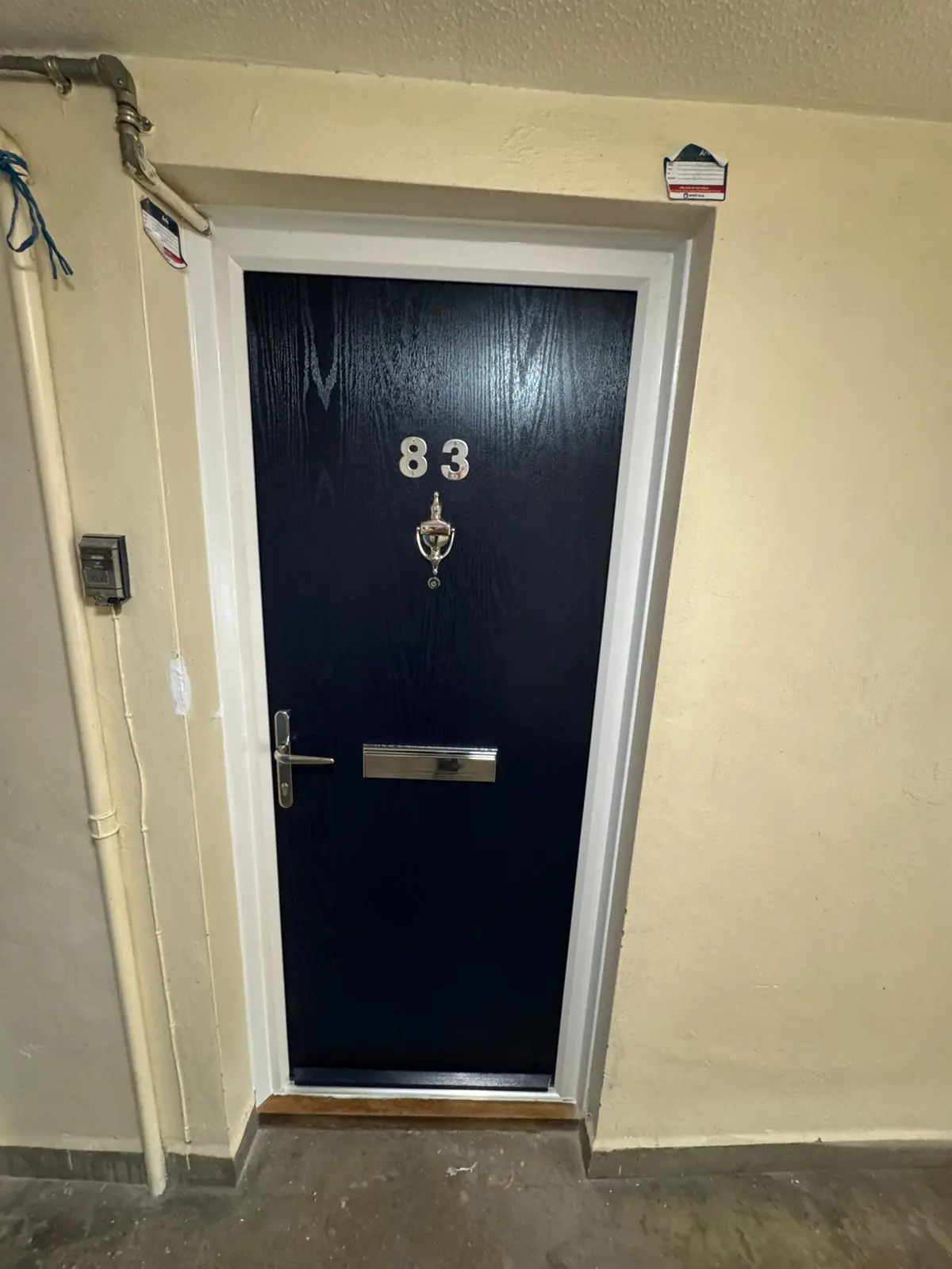 Dark secure residential entrance door with viewer, letter plate and lever handle