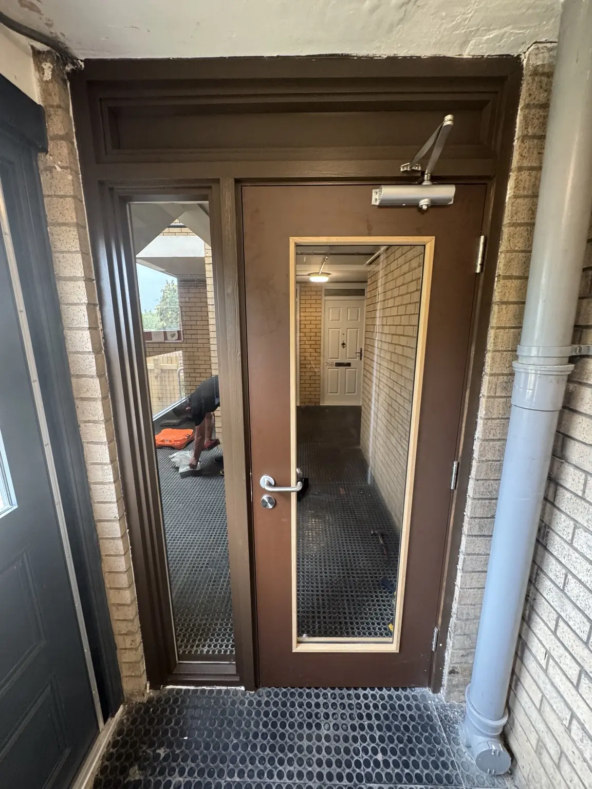 Timber communal entrance door with glazed sidelight and matching top overpanel