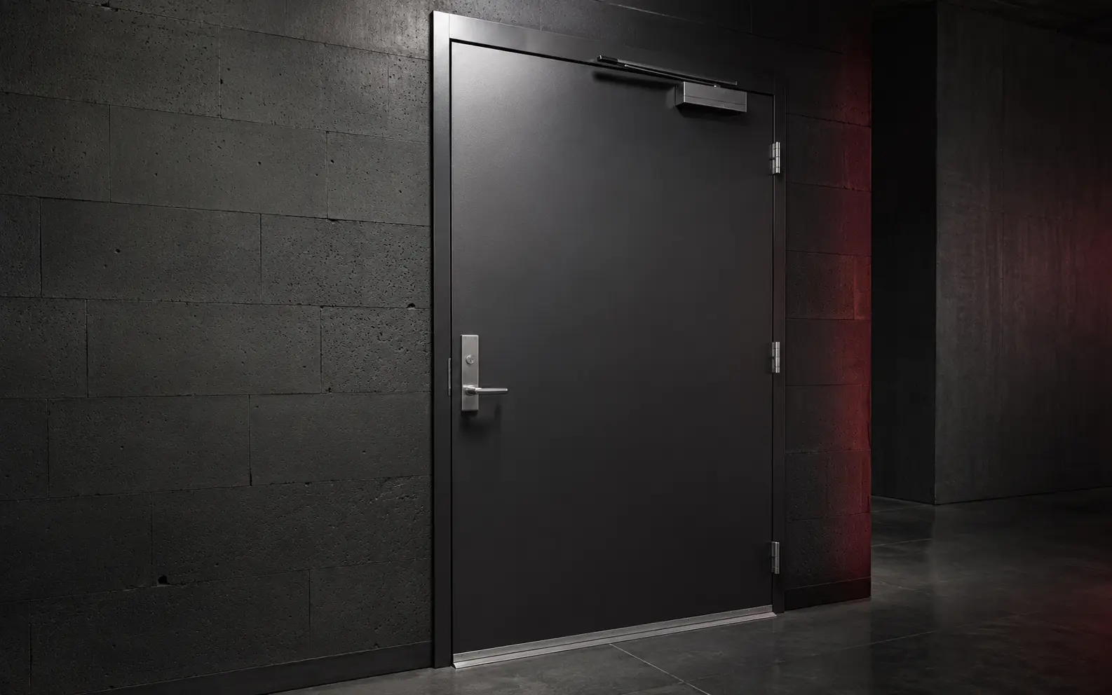 Black commercial steel fire doorset with a metal frame, closer, hinges and threshold